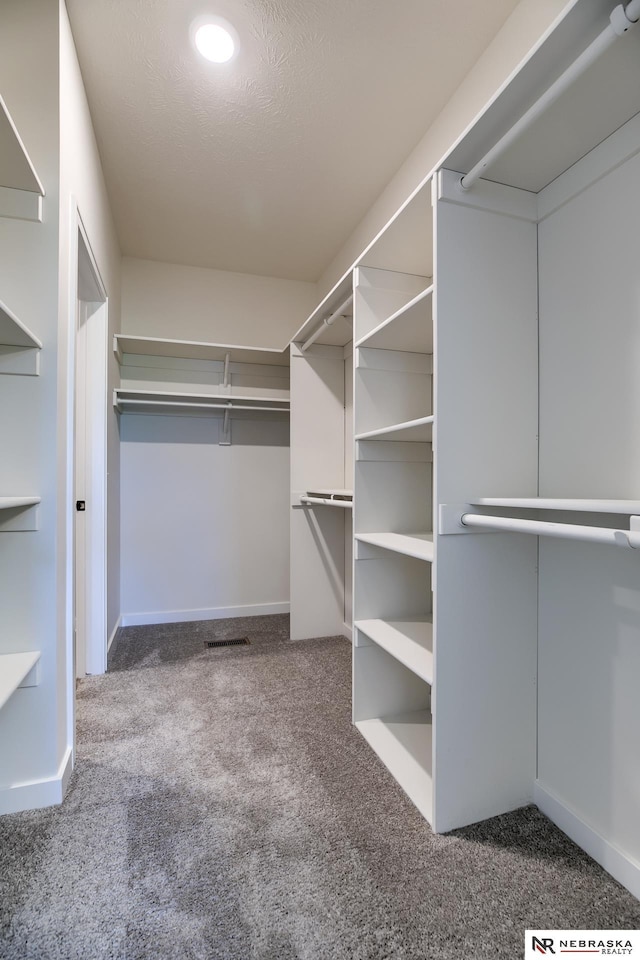 spacious closet with dark carpet