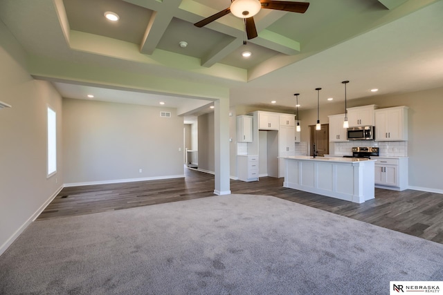 kitchen with hanging light fixtures, white cabinets, an island with sink, and appliances with stainless steel finishes