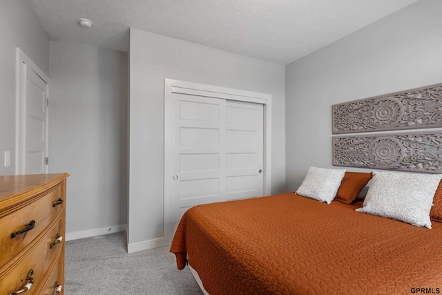 bedroom with a closet and light colored carpet