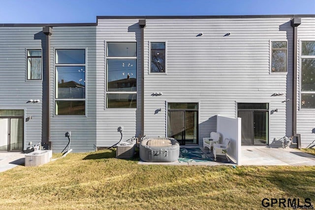 back of house featuring a patio and a lawn