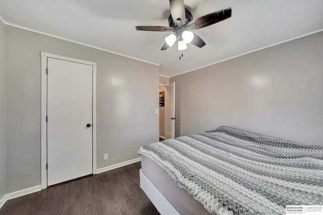 bedroom with ceiling fan, ornamental molding, dark wood-type flooring, and a closet