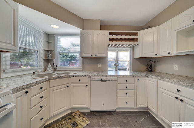 kitchen with dishwasher, white cabinetry, sink, and a wealth of natural light