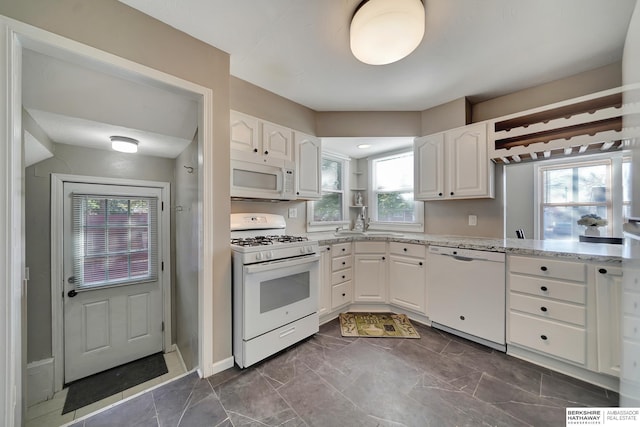 kitchen with white cabinets, white appliances, and plenty of natural light