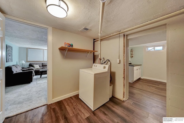 laundry area featuring a textured ceiling, washer / clothes dryer, and dark hardwood / wood-style floors