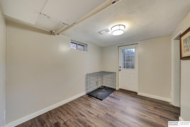 interior space with a textured ceiling, hardwood / wood-style flooring, and plenty of natural light