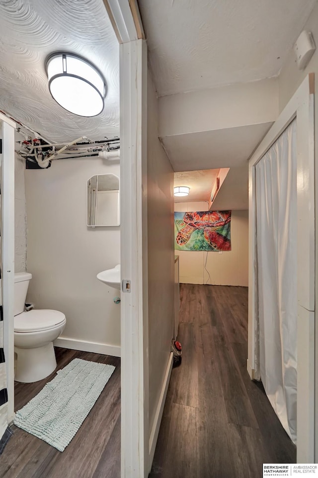 bathroom with wood-type flooring and toilet