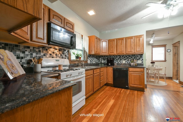 kitchen featuring ceiling fan, tasteful backsplash, light hardwood / wood-style flooring, a textured ceiling, and black appliances