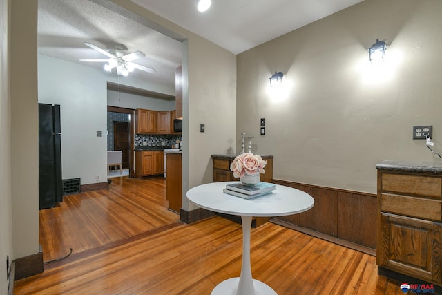 dining area with a textured ceiling, hardwood / wood-style flooring, and ceiling fan