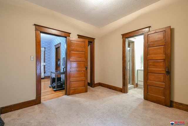 unfurnished bedroom with light colored carpet, a textured ceiling, and vaulted ceiling