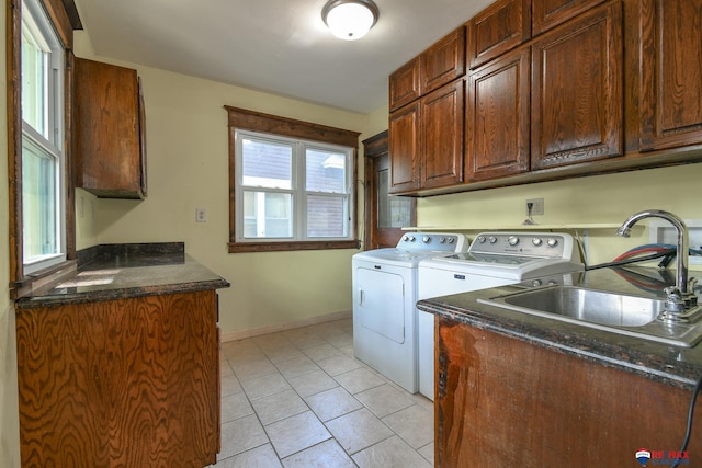 laundry room with cabinets, independent washer and dryer, light tile patterned floors, and sink