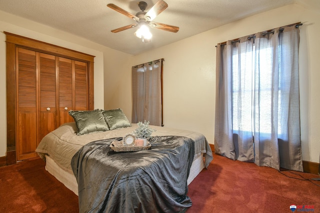 carpeted bedroom featuring multiple windows, ceiling fan, and a closet