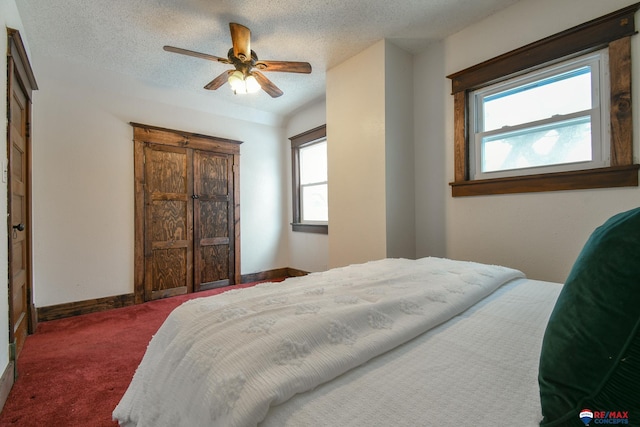 carpeted bedroom with ceiling fan and a textured ceiling