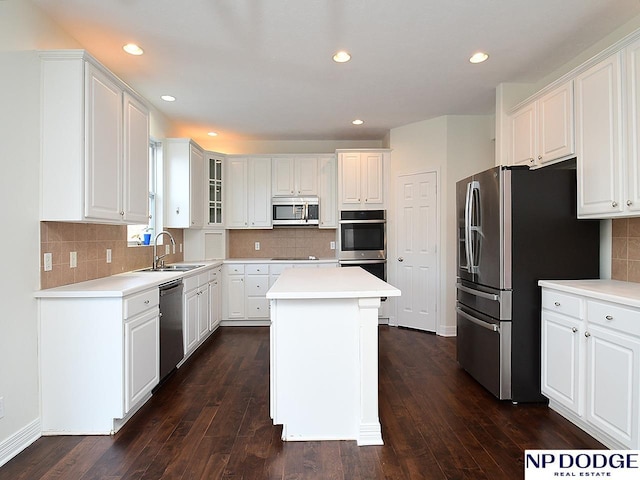 kitchen with white cabinets, dark hardwood / wood-style floors, a center island, and appliances with stainless steel finishes