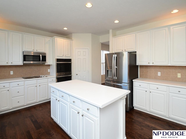 kitchen featuring decorative backsplash, appliances with stainless steel finishes, dark wood-type flooring, white cabinets, and a kitchen island