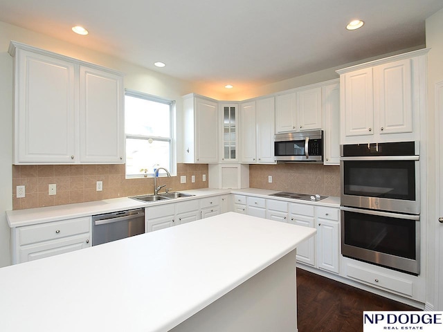 kitchen with white cabinets, sink, appliances with stainless steel finishes, and dark wood-type flooring