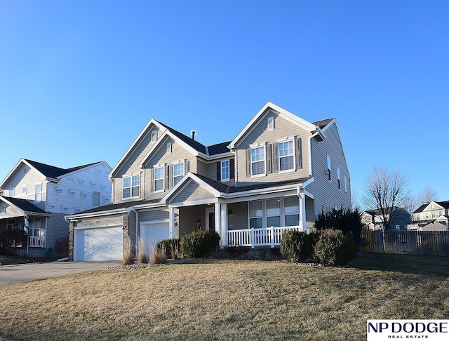 view of front facade featuring a front lawn, covered porch, and a garage