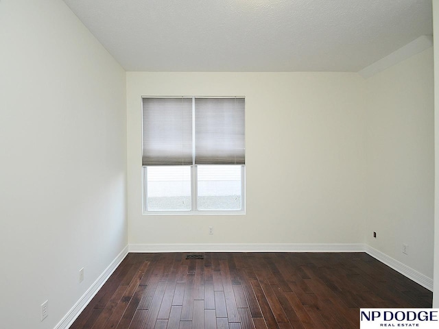 spare room featuring dark wood-type flooring