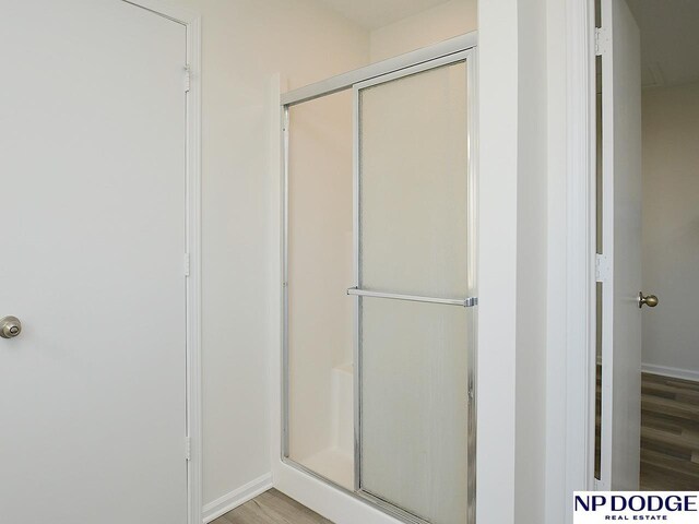 bathroom featuring a shower with door and hardwood / wood-style floors