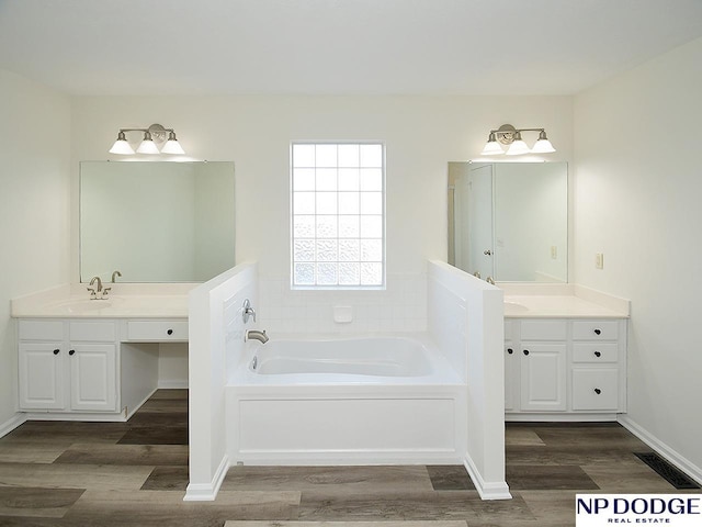 bathroom featuring a bathing tub, vanity, and hardwood / wood-style flooring