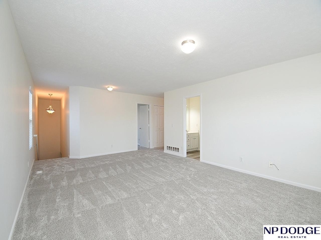 carpeted spare room featuring a textured ceiling