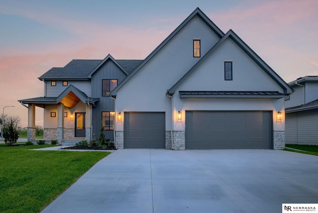 modern farmhouse style home featuring a lawn and a garage