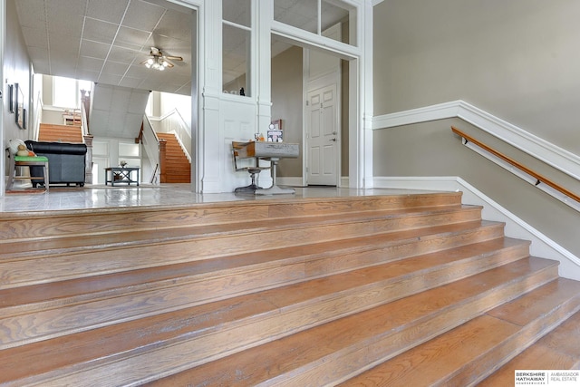 staircase featuring ceiling fan