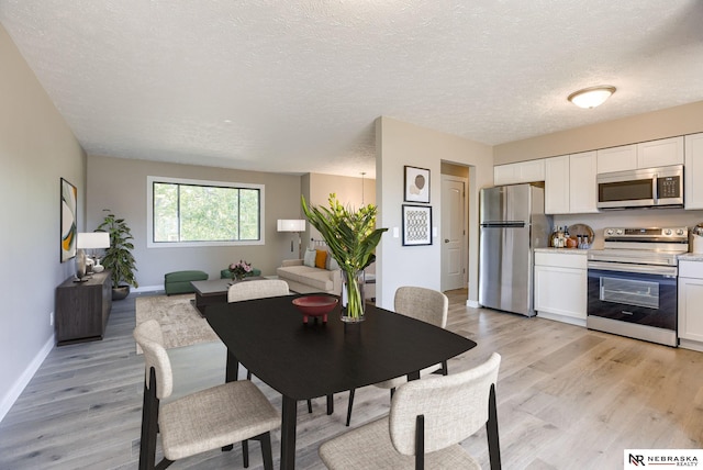 dining space featuring a textured ceiling and light hardwood / wood-style flooring