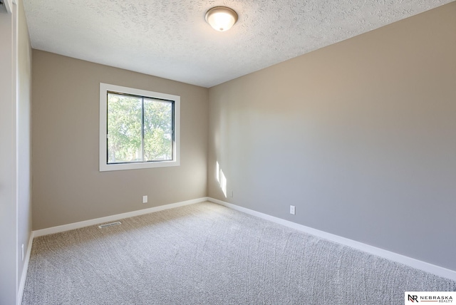 carpeted spare room featuring a textured ceiling