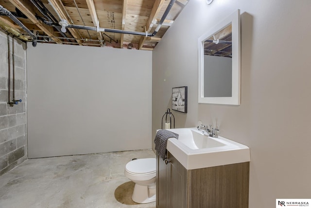 bathroom with vanity, concrete floors, and toilet