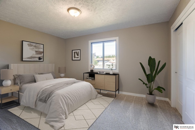 bedroom featuring a closet, light colored carpet, and a textured ceiling