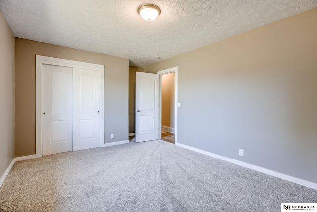 unfurnished bedroom with a closet, carpet floors, and a textured ceiling