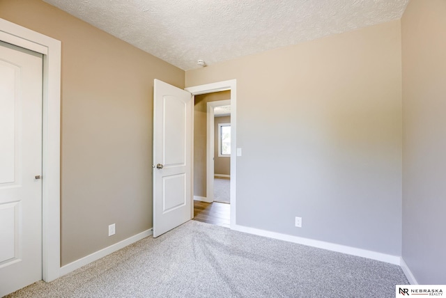 unfurnished bedroom featuring carpet flooring and a textured ceiling