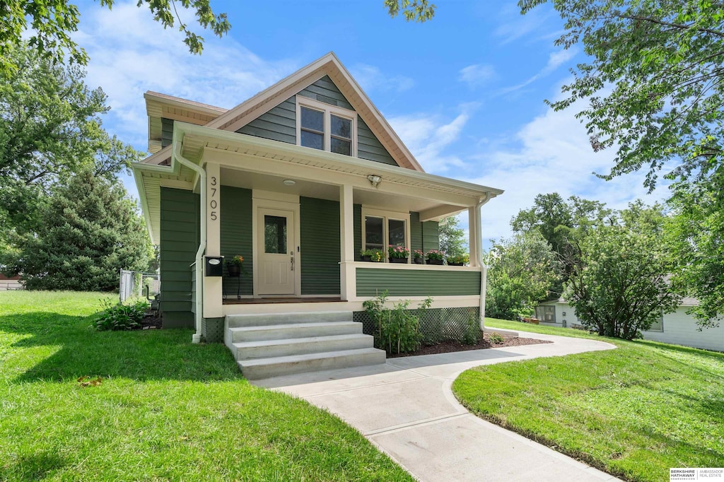 bungalow featuring a porch and a front lawn