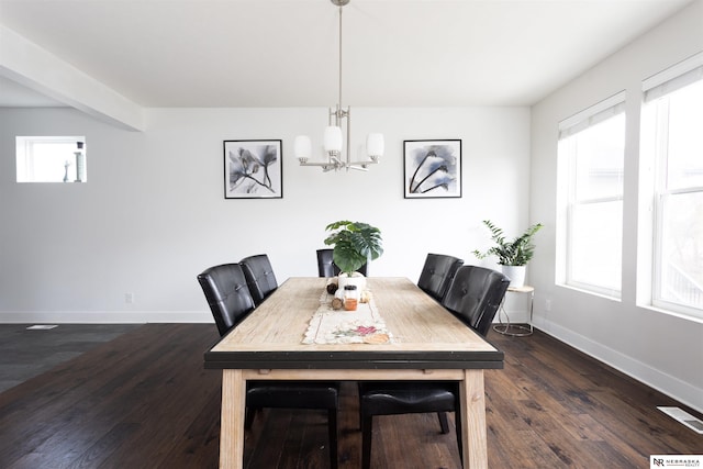 dining space featuring a healthy amount of sunlight, dark hardwood / wood-style floors, and an inviting chandelier