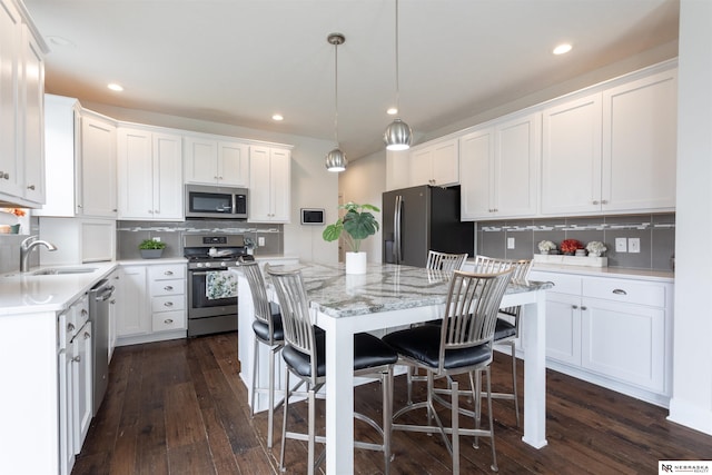 kitchen with white cabinets, sink, a kitchen island, and stainless steel appliances