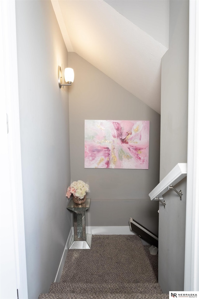 staircase featuring carpet, a baseboard radiator, and vaulted ceiling