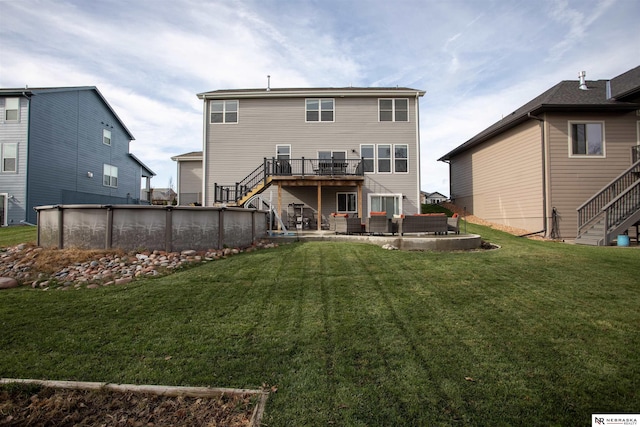 rear view of house featuring a patio area, a yard, and a pool side deck