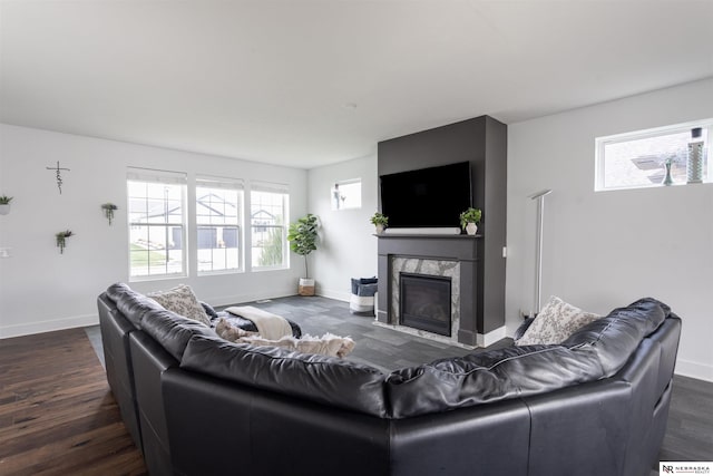 living room with a high end fireplace and dark wood-type flooring