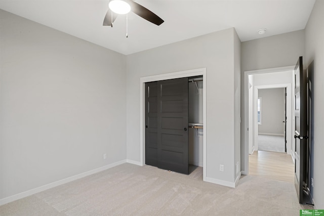 unfurnished bedroom featuring ceiling fan, a closet, and light carpet