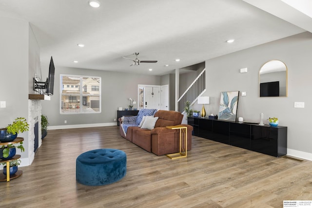 living room with ceiling fan and light hardwood / wood-style floors