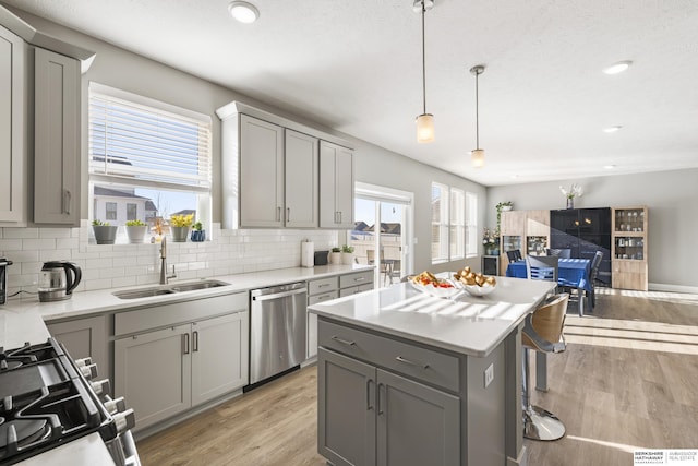 kitchen with appliances with stainless steel finishes, gray cabinetry, and sink