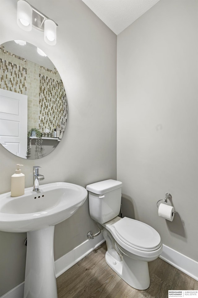 bathroom featuring hardwood / wood-style floors, toilet, and sink