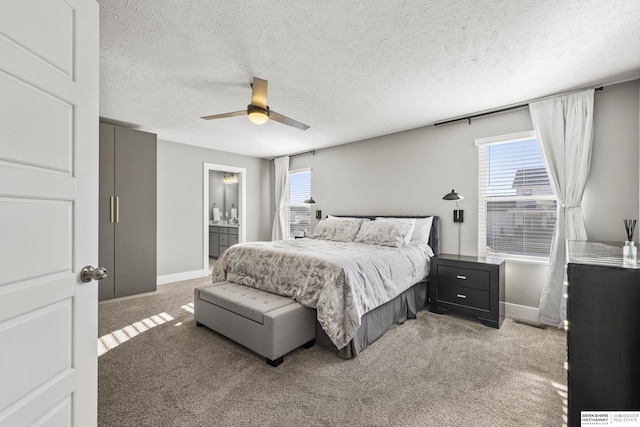 carpeted bedroom with ceiling fan, a textured ceiling, connected bathroom, and multiple windows