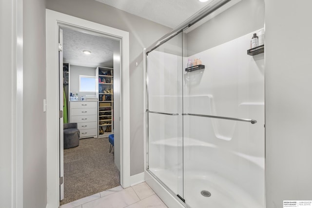 bathroom featuring tile patterned flooring, a textured ceiling, and walk in shower