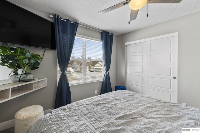 bedroom featuring ceiling fan, a closet, and a textured ceiling