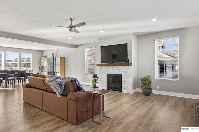 living room with a fireplace, hardwood / wood-style floors, plenty of natural light, and ceiling fan