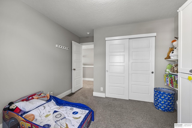 carpeted bedroom with a textured ceiling and a closet