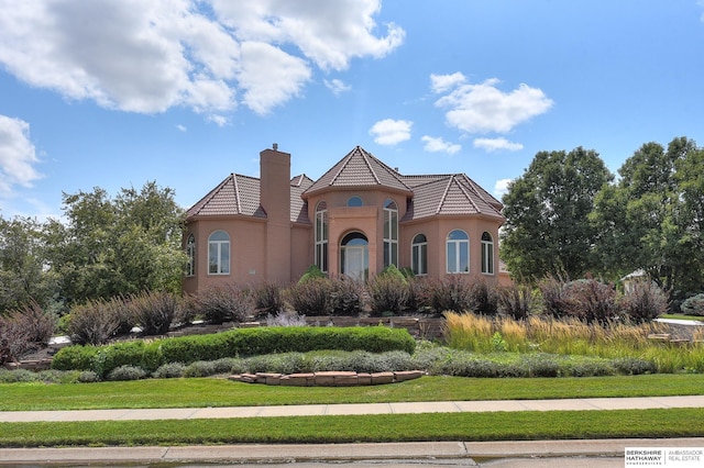 mediterranean / spanish-style home with a front lawn