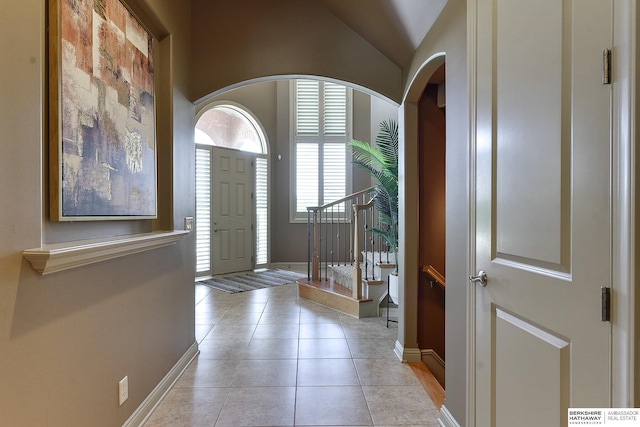 tiled entryway with vaulted ceiling