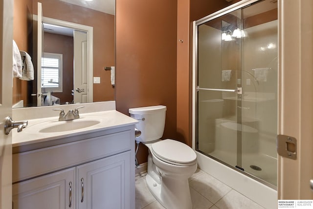 bathroom featuring tile patterned flooring, toilet, an enclosed shower, and vanity